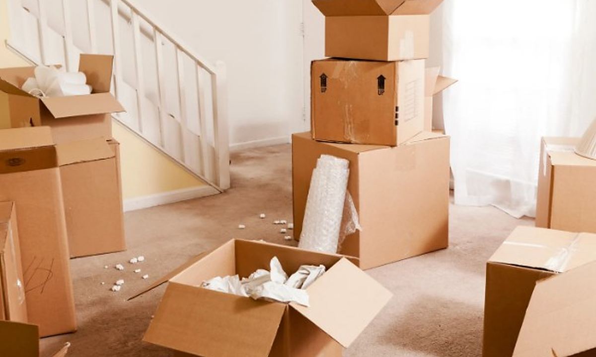 Clasificación de enseres en un vaciado Cajas abiertas y enseres clasificados en el salón de una vivienda durante el vaciado