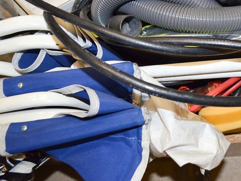Enseres acumulados en un trastero: sillas plegables, mangueras y cables