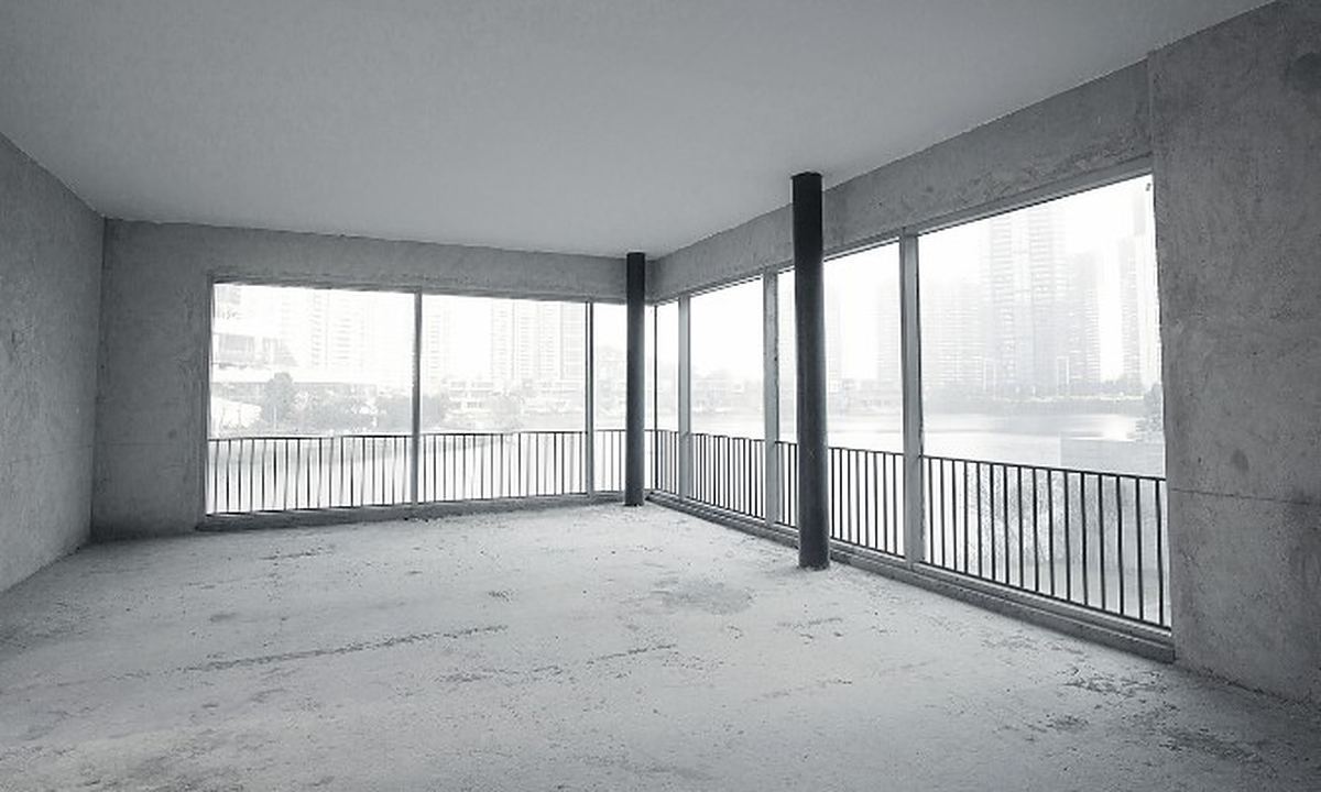 Piso vaciado antes de empezar la obra Vivienda sin muebles con el suelo en bruto y grandes ventanales, preparada para la reforma