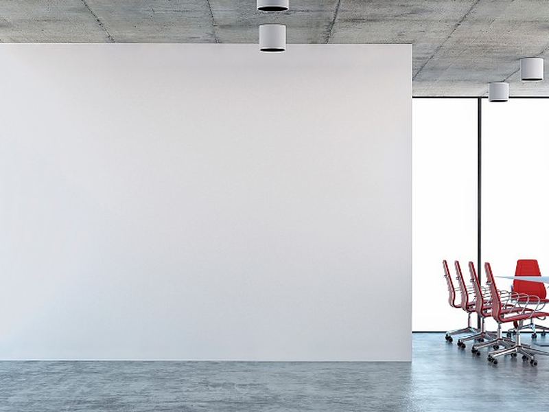 Sala diáfana de oficina vaciada, con la mesa de reuniones como único mobiliario